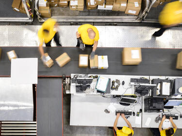Team members process and sort packages inside a distribution center