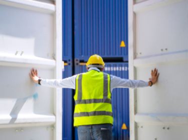 Lavoratore che apre le porte di un container di spedizione Lavoratore che apre le porte di un container di spedizione